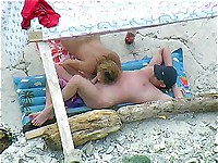 A nudist couple enjoys having oral sex on a beach where voyeurs spy